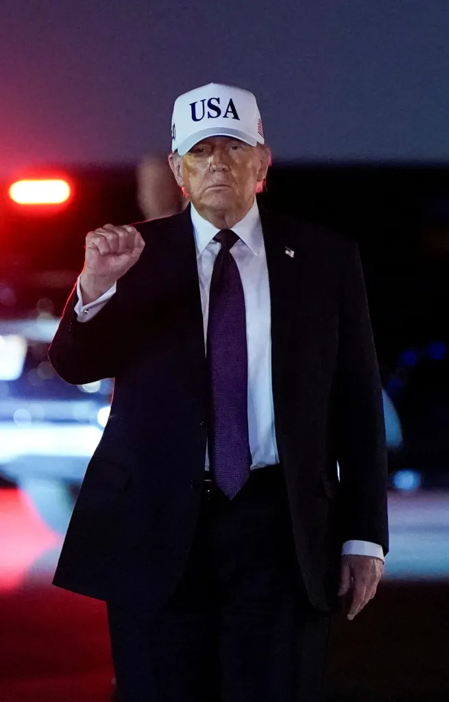 Donald Trump is walking and making a fist with his hands. 