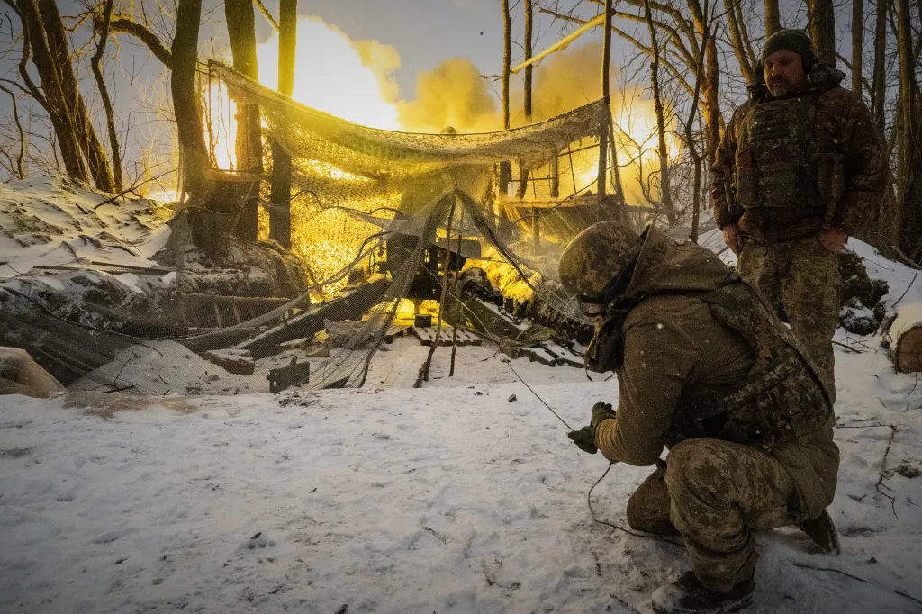 Ukrainian soldiers fire at Russian positions from a snowy, wooded area.