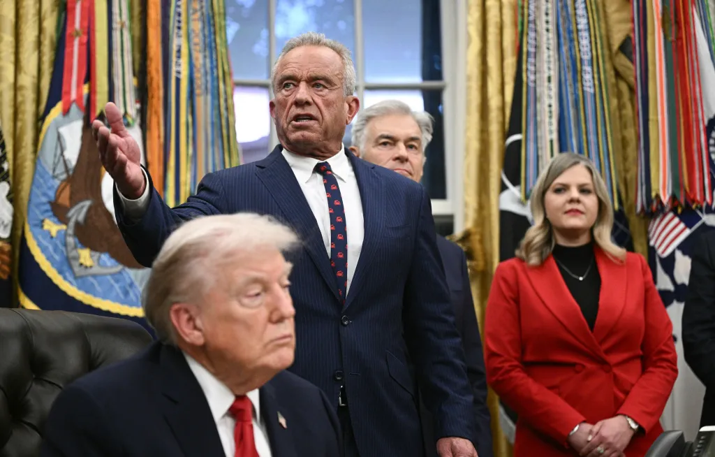 Robert F. Kennedy Jr. speaks at the Oval Office, with Donald Trump seated in the foreground.