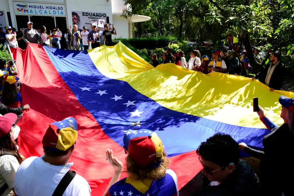 Venezuelan expatriates in Mexico City hold a large Venezuelan flag to celebrate the arrest of President Nicolás Maduro.