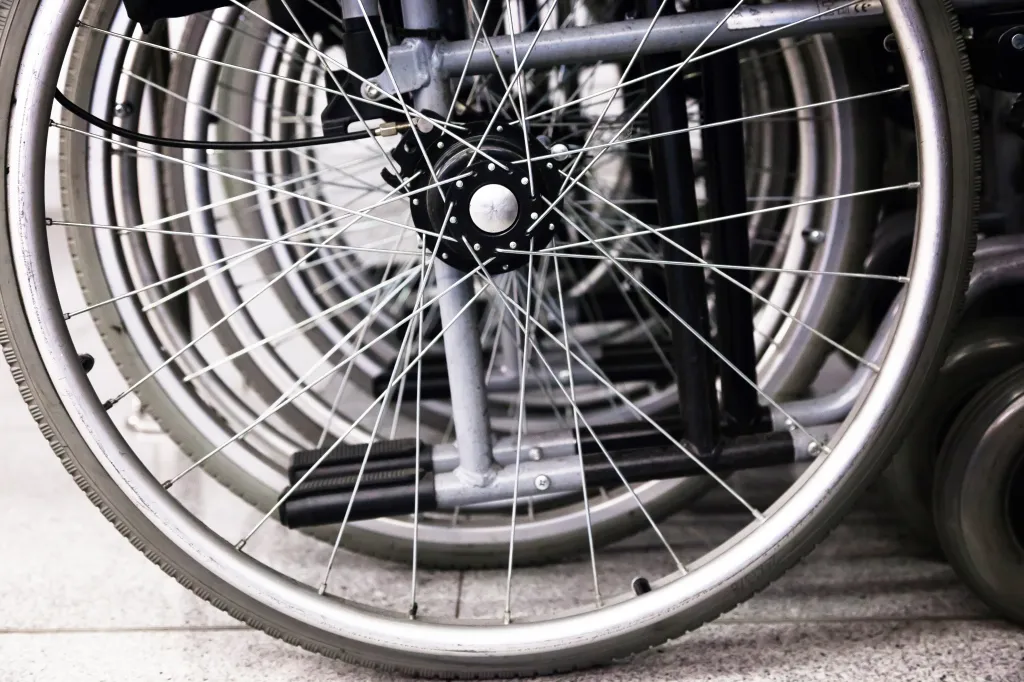 Close-up of several wheelchairs parked together in an airport terminal.