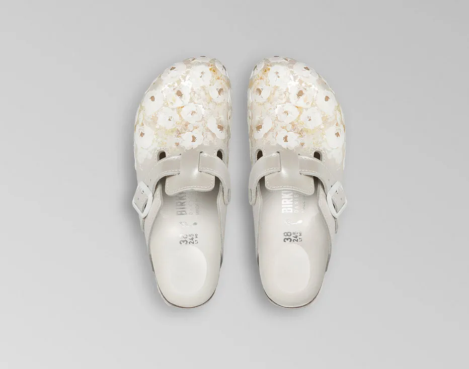 Pair of white clogs with a floral design.