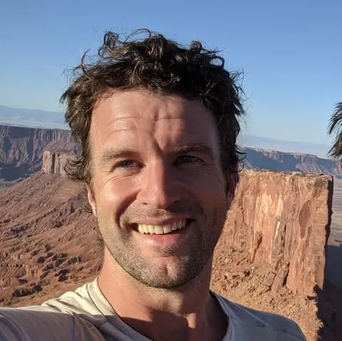 Robert Carroll smiling with a canyon in the background.