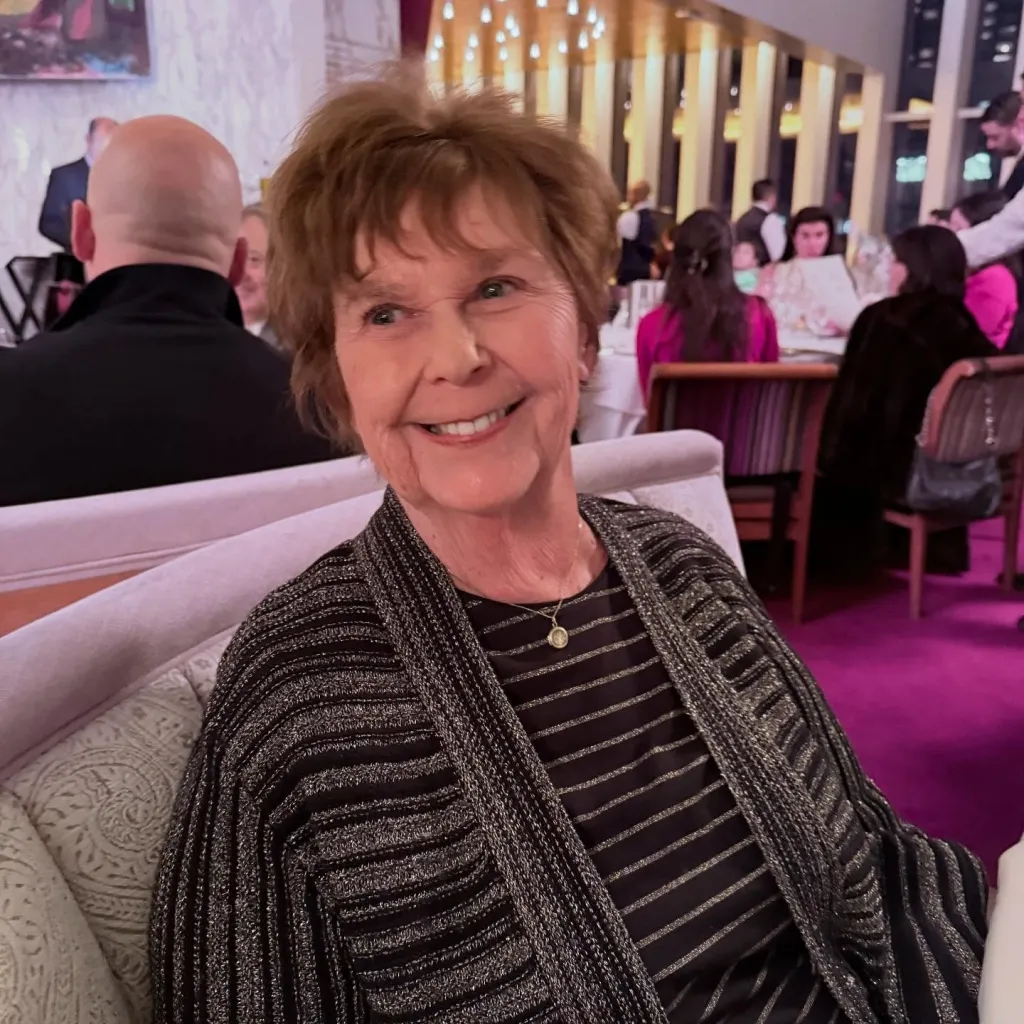 Nancy Guthrie smiling while seated at a restaurant.