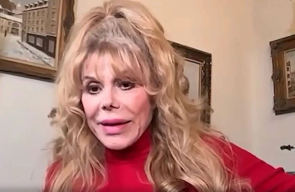 Charo with blonde hair wearing a red turtleneck.