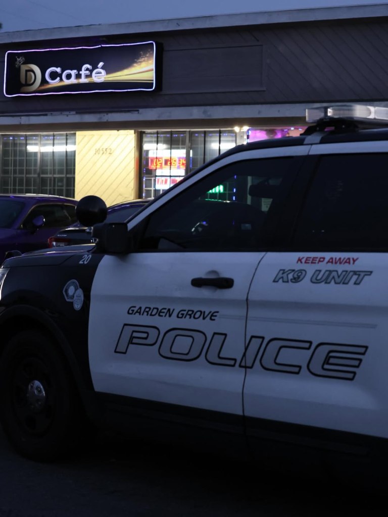 A Garden Grove Police K9 Unit vehicle parked outside a café at night.