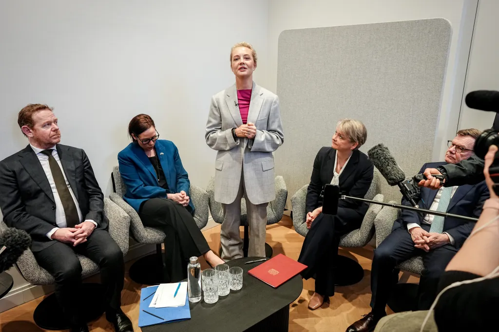 Yulia Navalnaya gives a press statement at the Munich Security Conference surrounded by four seated people.