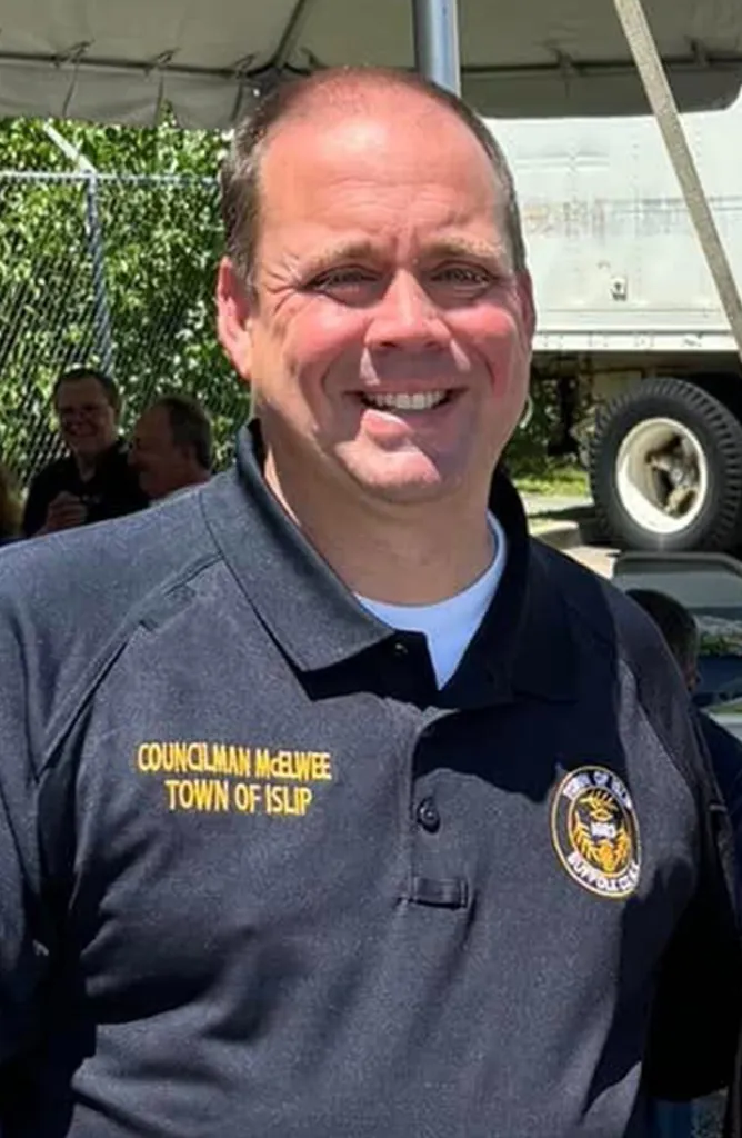 Councilman Michael McElwee smiling while wearing a dark polo shirt with 