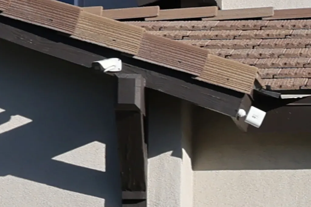 Two security cameras mounted on a house's exterior.