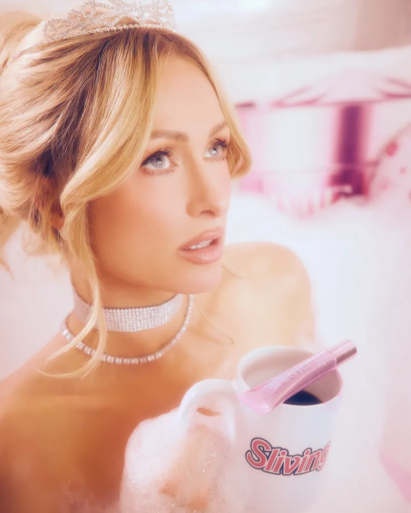 Paris Hilton in a bubble bath wearing a tiara and holding a coffee mug with