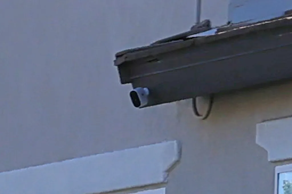 Outdoor security camera mounted on a house eave.