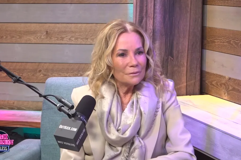 Kathie Lee Gifford wearing a light-colored suit and scarf while speaking into a microphone.