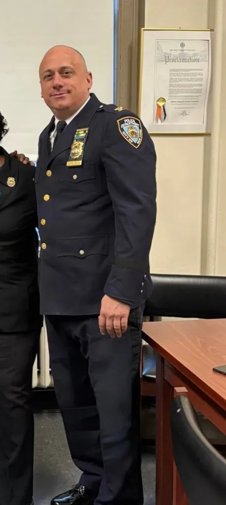 A police officer in uniform with a New York Police Department patch on his sleeve.