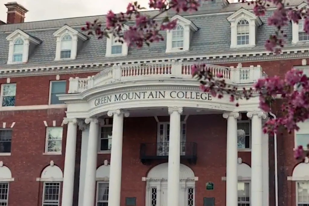 The Green Mountain College building with blooming trees in the foreground.