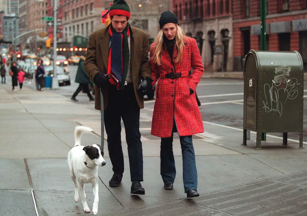 John F. Kennedy Jr. and Carolyn Bessette Kennedy walk their dog on a city street.