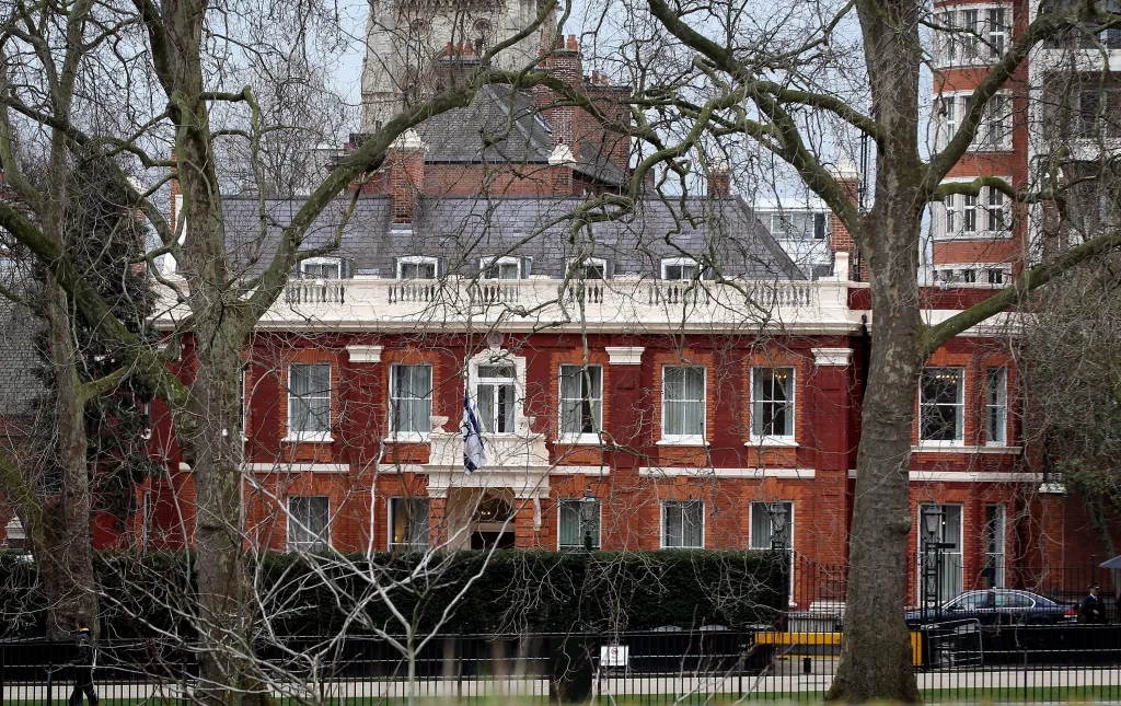 The Israeli Embassy in London, visible through bare tree branches and a fence.