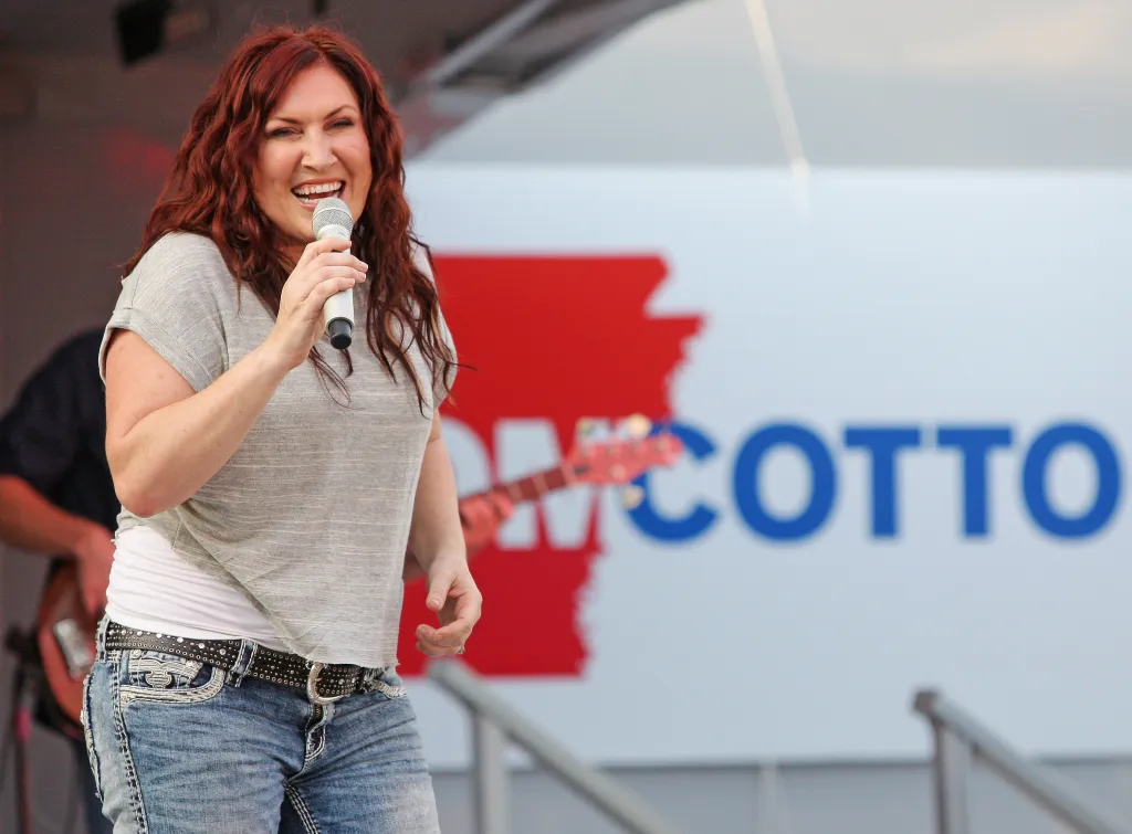 Jo Dee Messina singing into a microphone on stage.