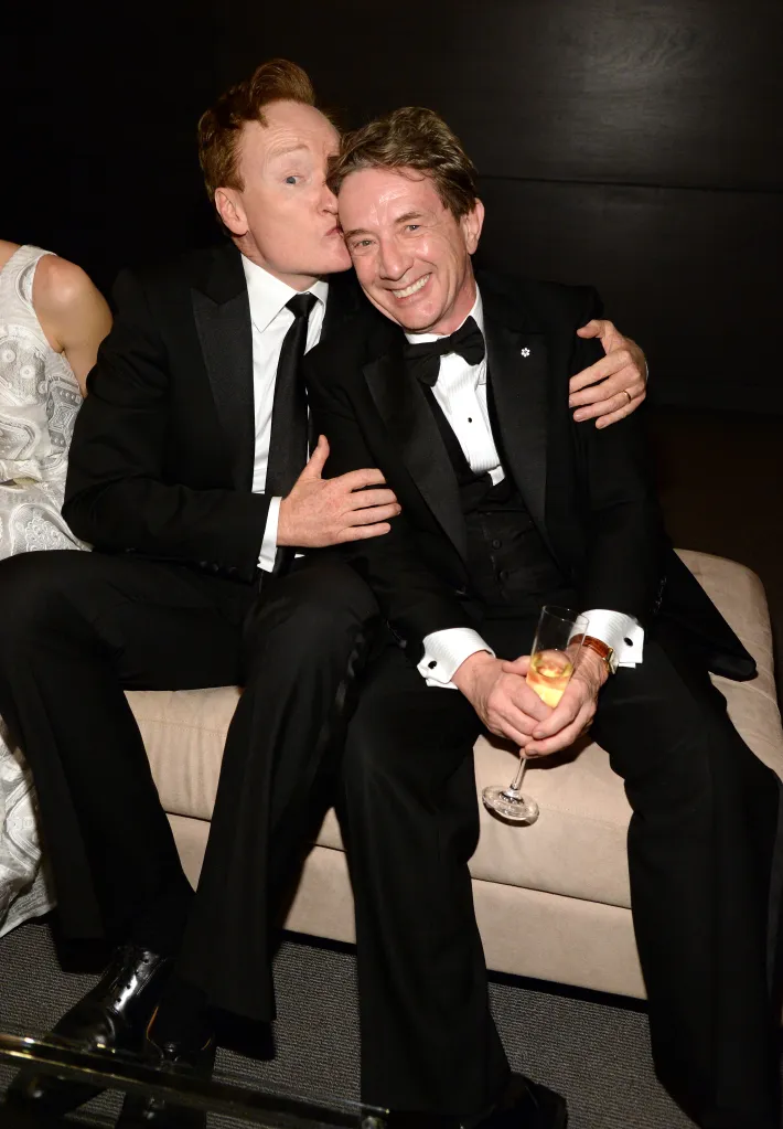 Conan O'Brien kisses Martin Short on the cheek at the 2016 Vanity Fair Oscar Party.