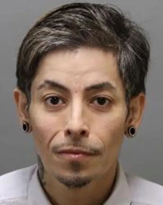 Booking photo of Rene Campos, with dark hair, a goatee, and ear gauges.