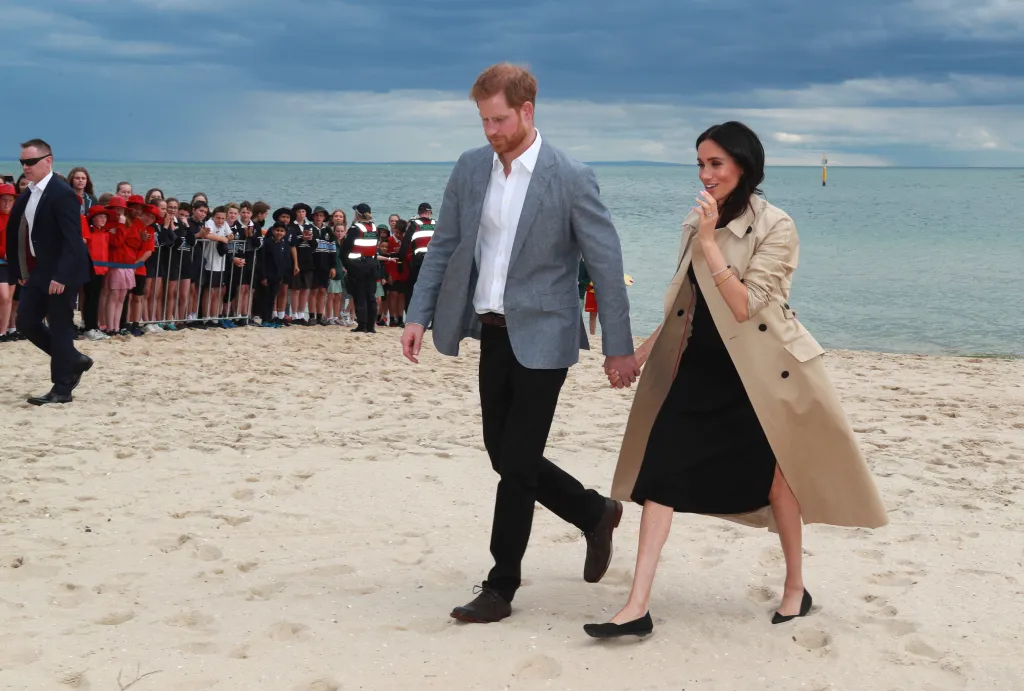 Prince Harry and Meghan Markle walk hand-in-hand on the beach in Melbourne, Australia.