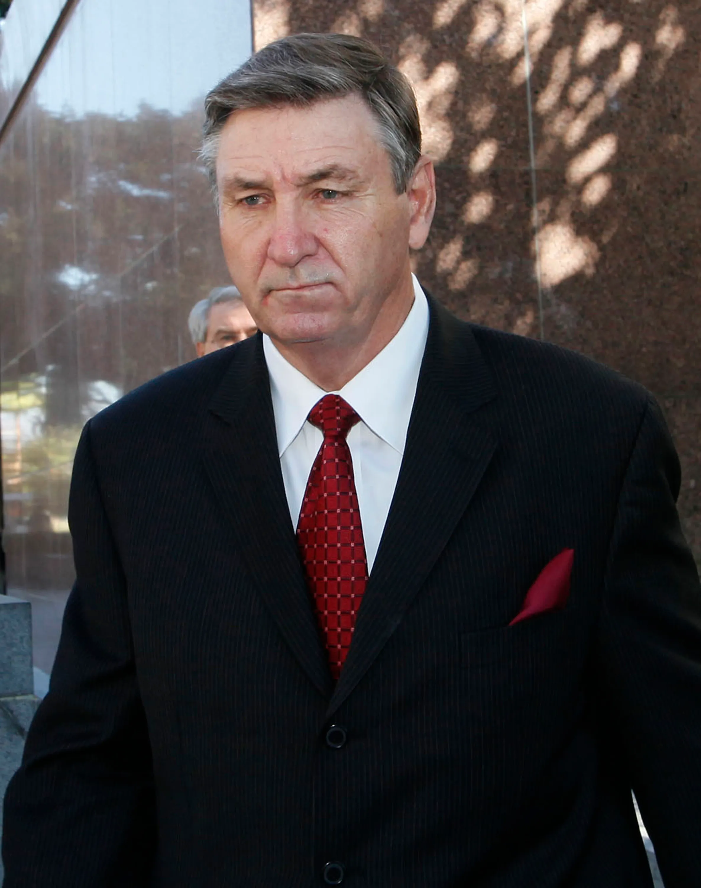 Jamie Spears, father of Britney Spears, in a dark suit with a red tie and pocket square.