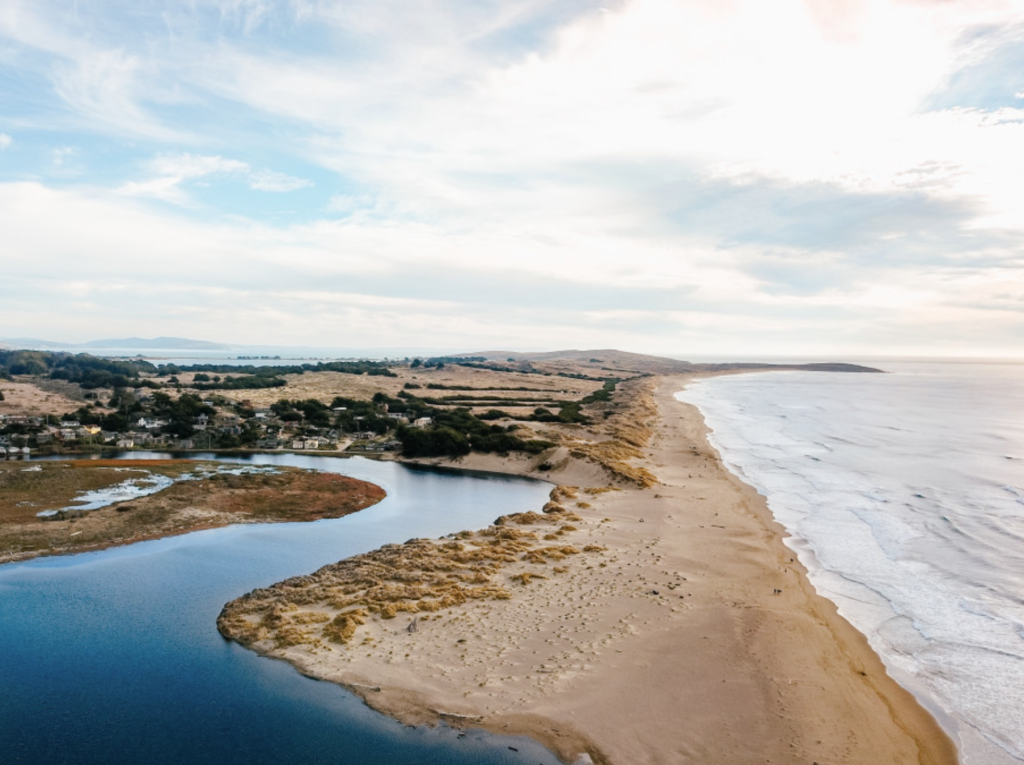 Aerial view of Salmon Creek Beach where it meets a river on the Sonoma County coastline.