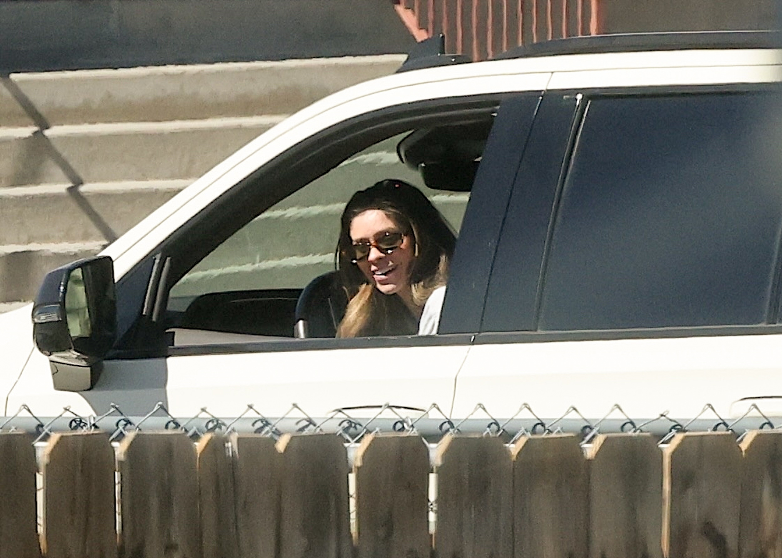 Taylor Frankie Paul in a white vehicle smiling with sunglasses on.