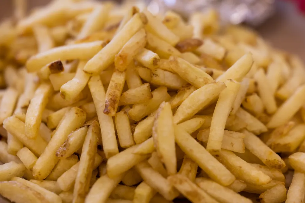 A close-up of a pile of golden-brown french fries.