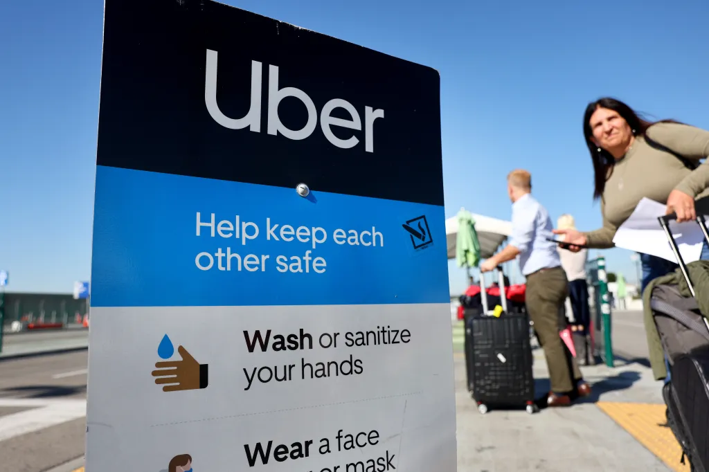 Uber sign with safety guidelines at Los Angeles International Airport (LAX).
