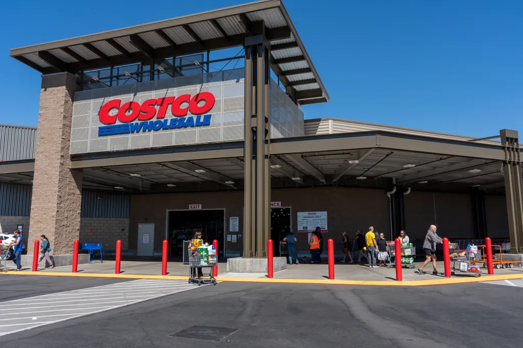 Exterior of a Costco store with customers entering and exiting.