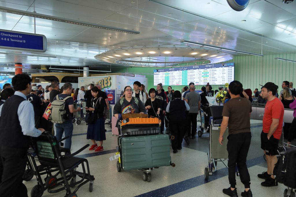 Passengers crowding Los Angeles International Airport during the Independence Day travel surge.