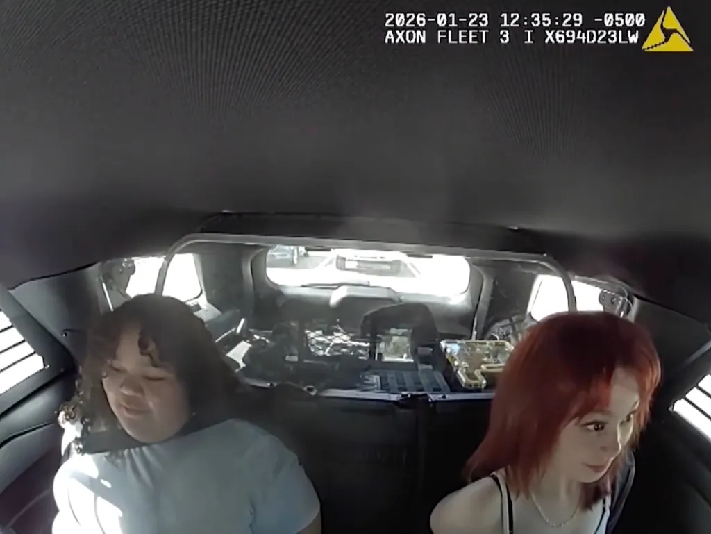Footage of Isabelle Valdez and Lois Lippert in the back seat of a patrol car.