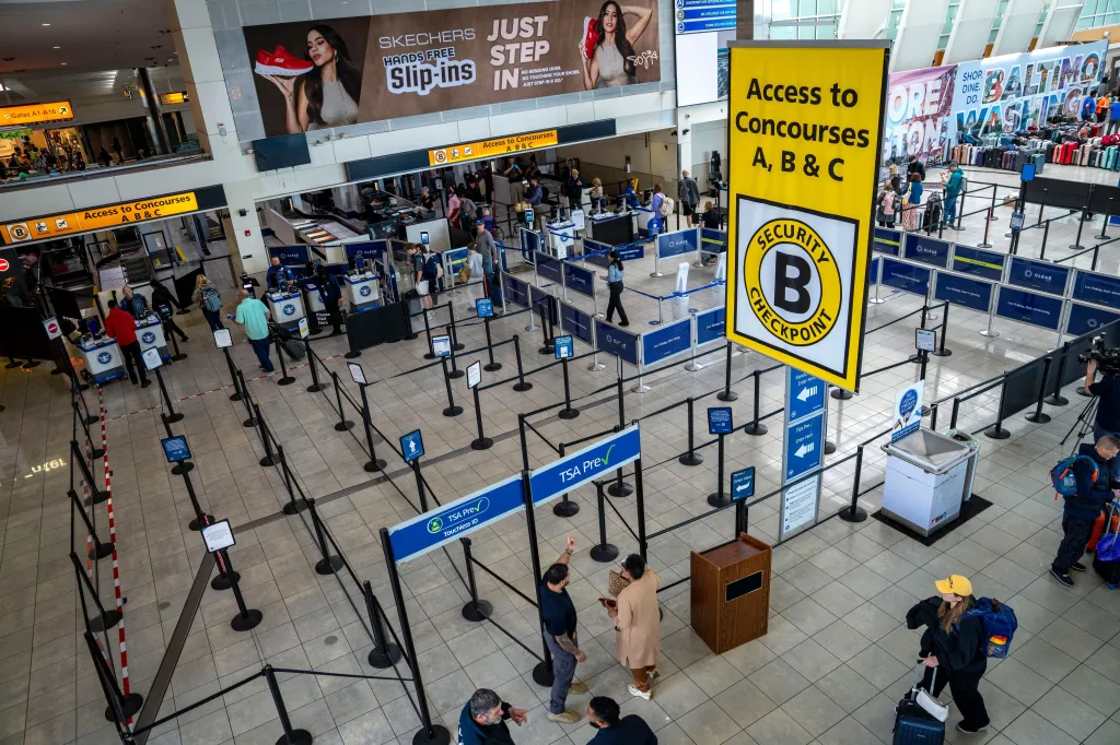 An ICE agent assisting a traveler at Baltimore/Washington International Thurgood Marshall Airport.
