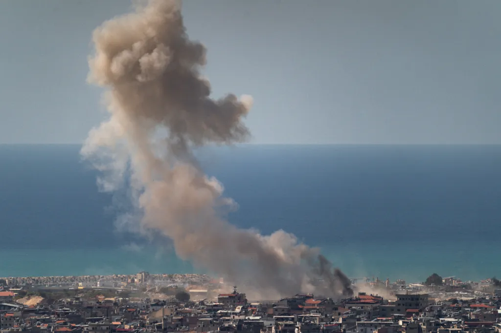 View of an IDF airstrike in Beirut, Lebanon, with smoke rising over buildings near the sea.