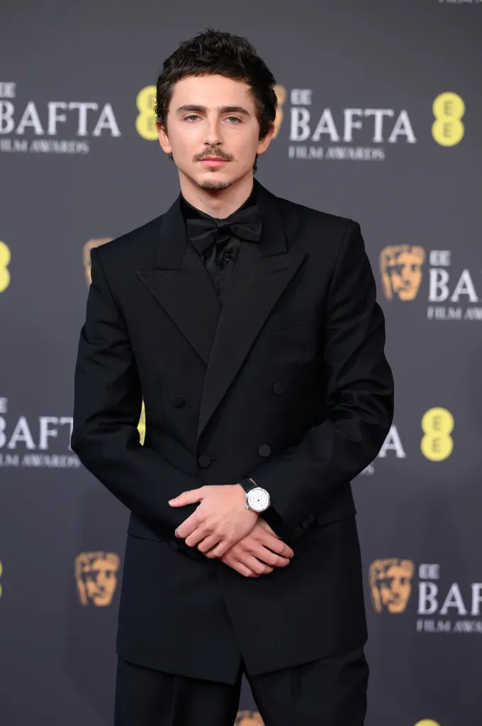 Timothée Chalamet attends the 2026 EE BAFTA Film Awards, wearing a black double-breasted suit and bow tie.