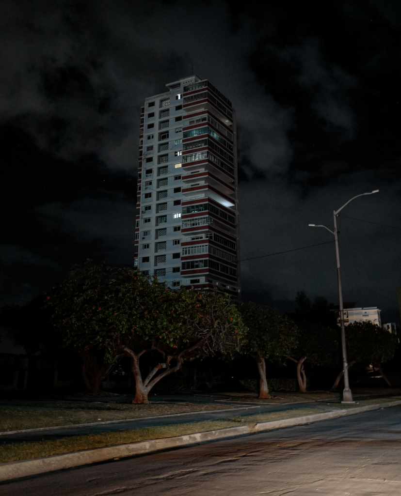An apartment building in Havana experiences a nationwide blackout, with only a few lights on, highlighting the energy crisis.