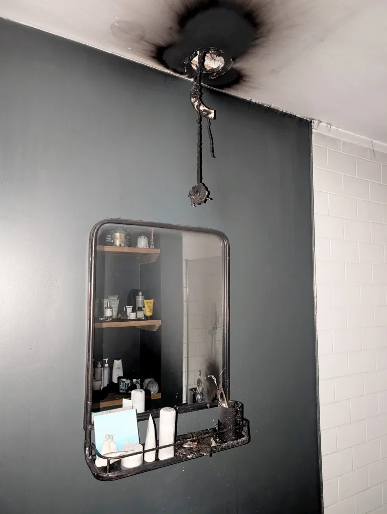 Damage to a bathroom ceiling and toothbrush holder after an electric toothbrush exploded.