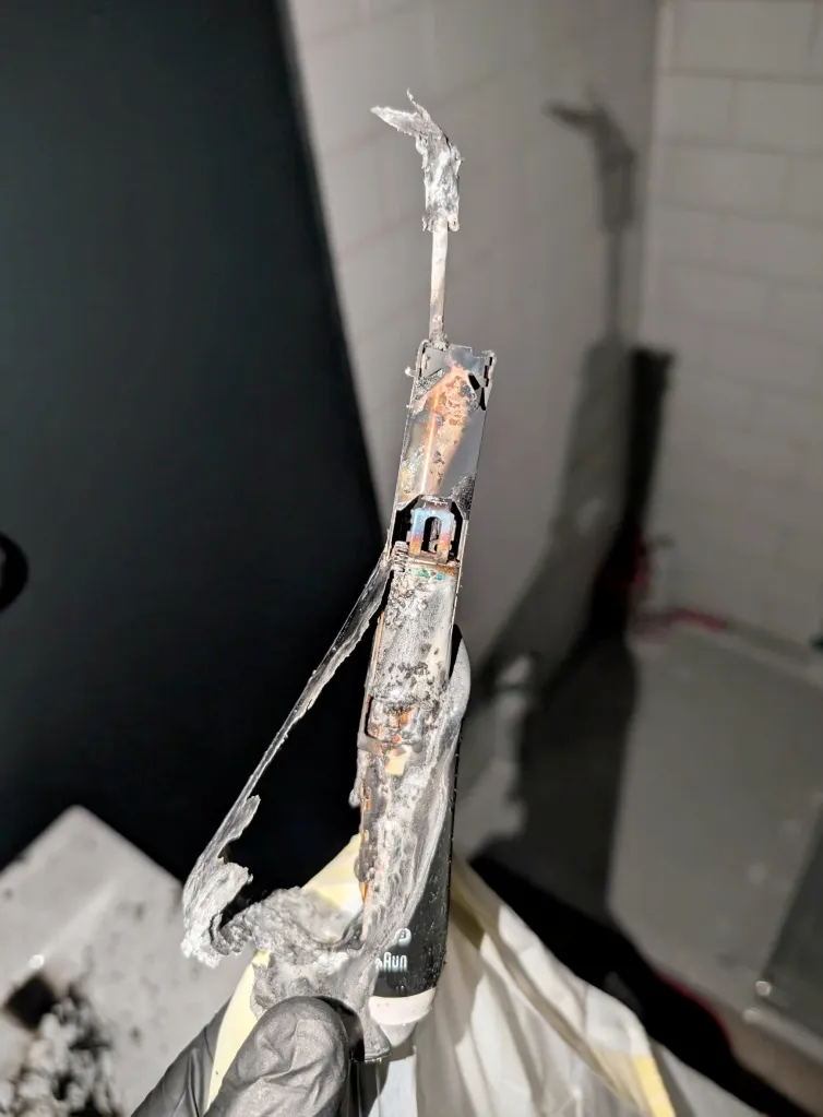 An electric toothbrush, melted and burnt, following an explosion and fire.