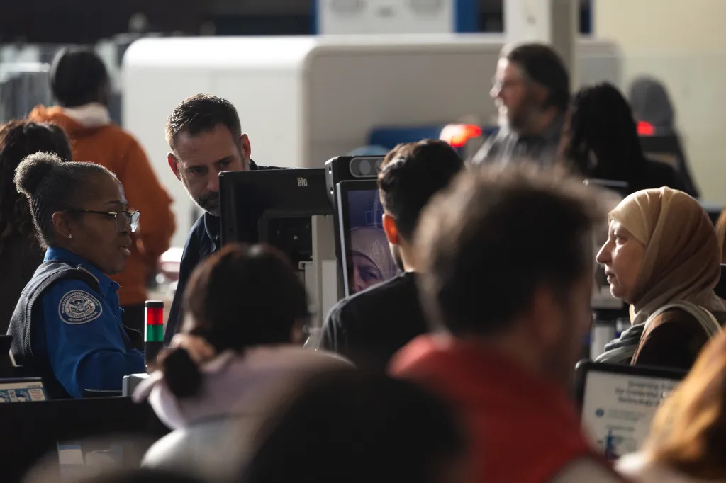 A Homeland Security Investigation Special Agent and a TSA agent check the identification of a traveler at Terminal E at George Bush Intercontinental Airport.