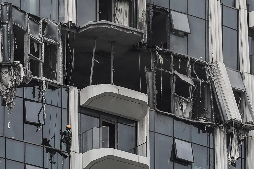 Steeplejack assessing damage on a building hit by a drone strike in Dubai.