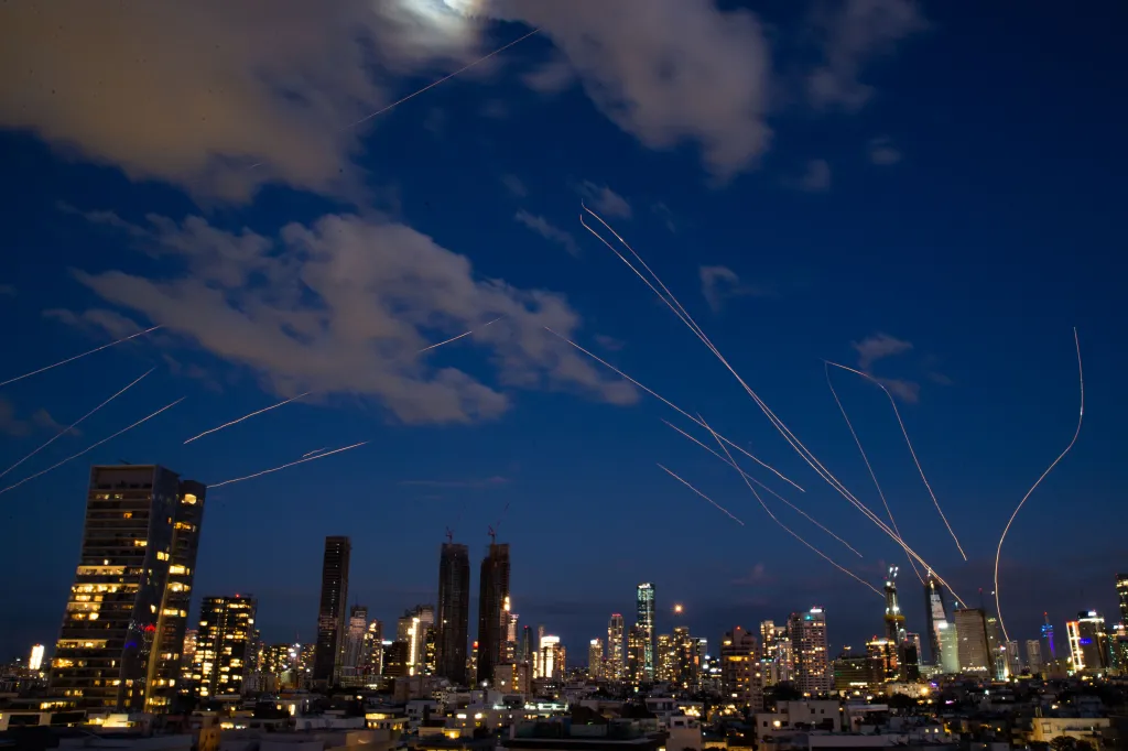 Long exposure photo of interceptor missile flare trails over Tel Aviv during major combat operations.