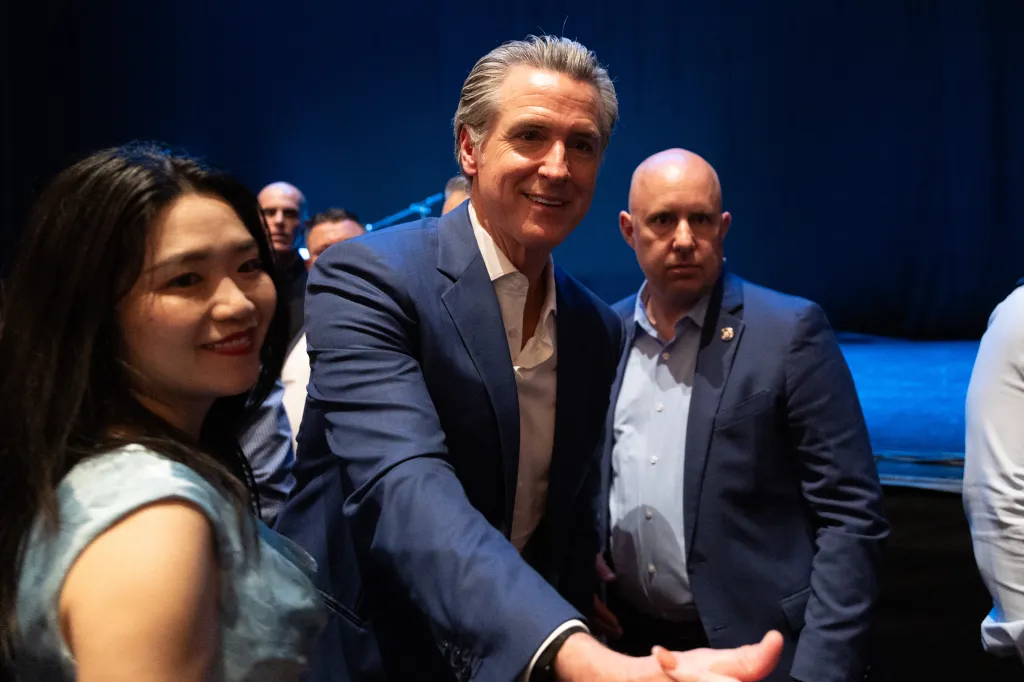 California Governor Gavin Newsom shaking hands with an attendee during his book tour.