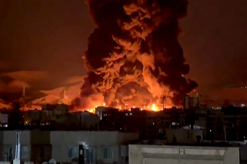Fire and smoke from an oil depot erupt over Tehran, Iran.