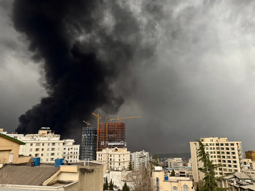 Smoke rising over buildings in Tehran, Iran, after airstrikes on oil depots.