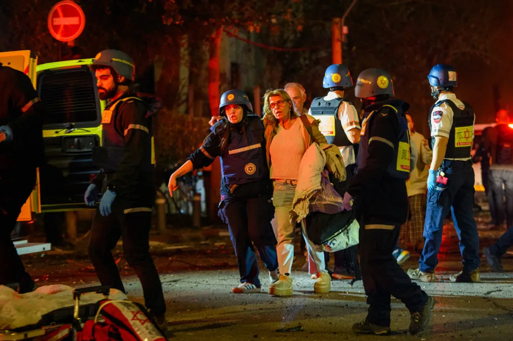 Emergency workers and civilians near a missile strike site in Tel Aviv, Israel.