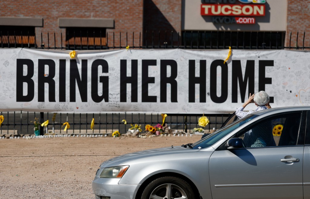 A person takes a photo of a Nanthy Guthrie memorial in front of the KVOA news station on March 03, 2026 in Tucson, Arizona.