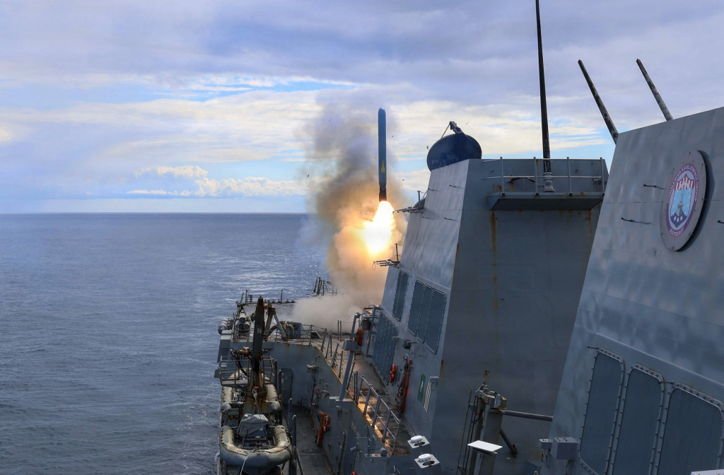 USS Thomas Hudner firing a Tomahawk land attack missile at sea.