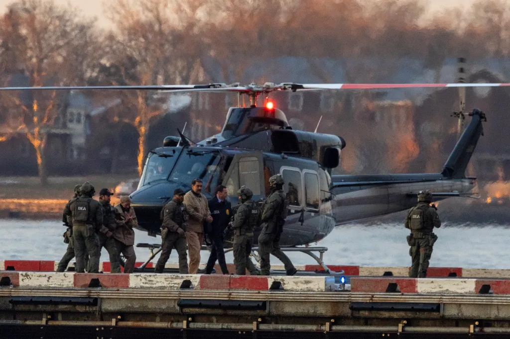 Former Venezuelan President Nicolás Maduro, in handcuffs, being escorted by DEA agents from a helicopter.