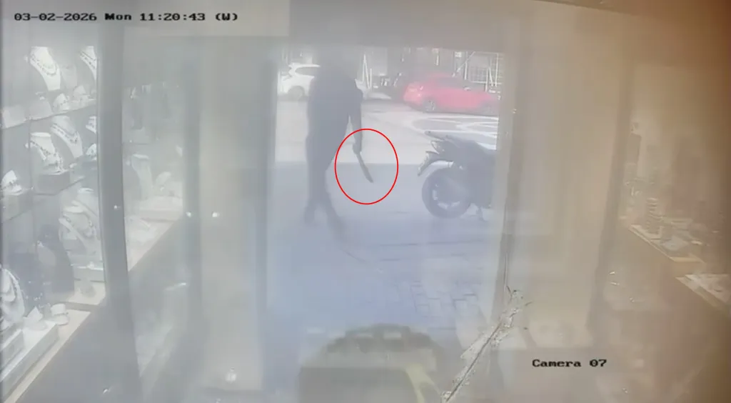 CCTV footage shows a person holding a machete, with a red circle highlighting it, standing outside a jewelry store.