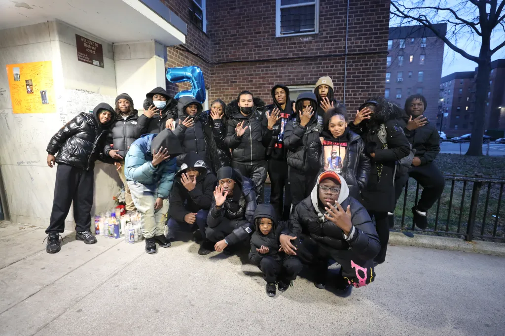 Members of the Sheepshead Bay Sharks football team hold up five fingers for Coleman's number after his death.